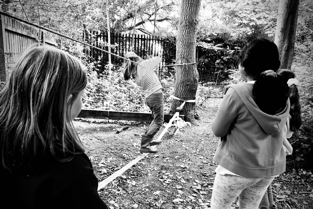 Children Balance on a slackline at Forest School.